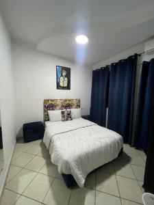 1 dormitorio con 1 cama con cortinas azules en Villa sonaba agadir, en Agadir