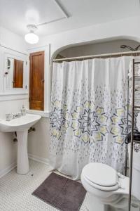 a bathroom with a shower curtain and a toilet at Charming Steps to Strong/UofR by Airport/Dwnt/RIT in Rochester