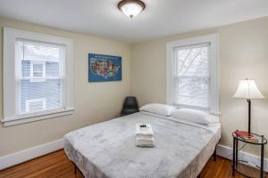 a bedroom with a large bed and two windows at Charming Steps to Strong/UofR by Airport/Dwnt/RIT in Rochester