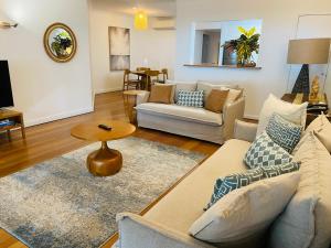 a living room with two couches and a table at BeachView Apartments at Villa Paradiso in Palm Cove