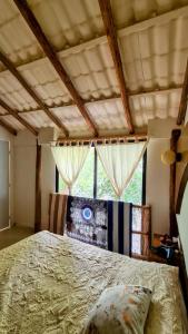 duże łóżko w pokoju z oknem w obiekcie Chiibal w mieście Tulum