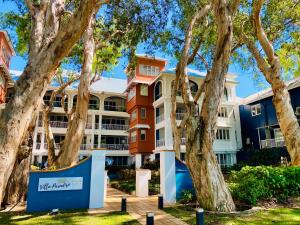 a building with trees in front of it at BeachView Apartments at Villa Paradiso in Palm Cove