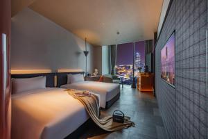 a hotel room with two beds and a tv at The Clouds Apartment in Shenzhen