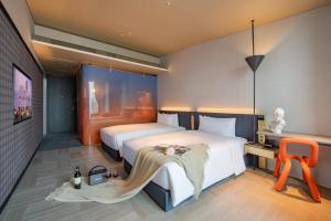 a hotel room with two beds and a chair at The Clouds Apartment in Shenzhen