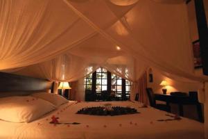 - une chambre avec un lit blanc orné de fleurs dans l'établissement Cham Villas Resort, à Mui Ne