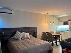 1 dormitorio con 1 cama y comedor con mesa en Elegante Estudio Nordelta Bay , Piscina, Parking en Tigre
