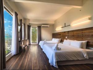 um quarto de hotel com duas camas e uma grande janela em Mandurah Hotel em Kuantan