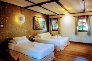 een kamer met 2 bedden in een kamer bij Rimsuan Garden Home in Chiang Mai