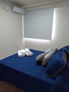 1 dormitorio con 1 cama azul y 2 almohadas en ML NORTE Departamento en San Salvador de Jujuy