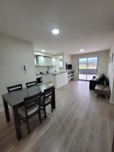 ein Wohnzimmer mit einem Tisch und Stühlen sowie eine Küche in der Unterkunft ML NORTE Departamento in San Salvador de Jujuy