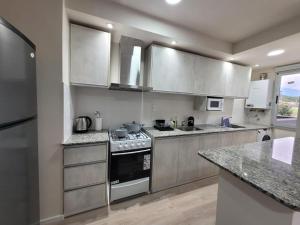 a kitchen with stainless steel appliances and granite counter tops at ML NORTE Departamento in San Salvador de Jujuy