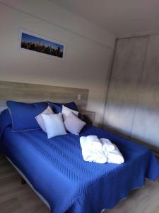 uma cama azul com toalhas por cima em ML NORTE Departamento em San Salvador de Jujuy