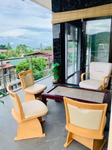 un portico con 3 sedie e un tavolo di VRT Brilliant Hotel a Cajidiocan