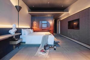 a bedroom with a white bed and a brick wall at The Clouds Apartment in Shenzhen