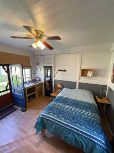 Schlafzimmer mit einem Bett und einem Deckenventilator in der Unterkunft Cabines Boréales in Rimouski