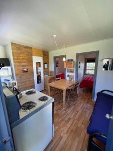 a kitchen with a stove and a table in a room at Cabines Boréales in Rimouski