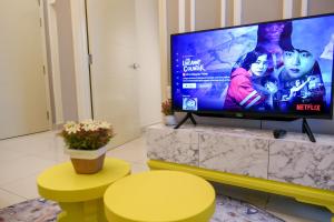 uma sala de estar com uma grande televisão de ecrã plano em Arte Mont Kiara Homestay em Kuala Lumpur