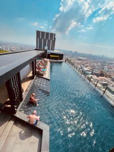 two men in a infinity pool on top of a building at The base condo 142 by Pupu in Pattaya Central