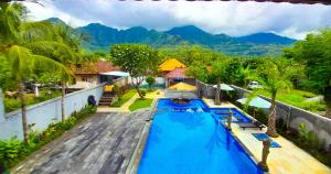 an aerial view of a swimming pool with mountains in the background at The Bali Menjangan Boutique Villas & Dive Center in Pemuteran