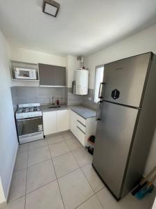 a small kitchen with a refrigerator and a stove at Departamento para cuatro personas in Cordoba