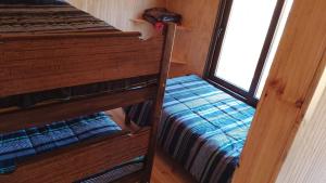 two bunk beds in a room with a window at Cabaña pullay in Cobquecura