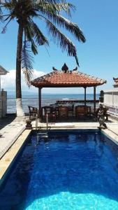 チャンディダサにあるCatra homestay beach apartmentsのスイミングプール(ガゼボ、テーブル、椅子付)