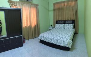 a bedroom with a bed and a flat screen tv at Ruhani Homestay 2 Kota Bharu Cheap and Comfortable in Kota Bharu