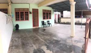 um quarto vazio de um edifício com duas cadeiras em Ruhani Homestay 2 Kota Bharu Cheap and Comfortable em Kota Bharu