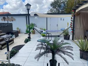 マイアミにあるTiny place w private hot jacuzzi 7 min to Miami international airportの鉢植えの植物とテーブルのあるパティオ