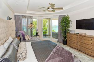 a bedroom with a bed and a flat screen tv at Sea Breeze, Grand Cayman in West Bay