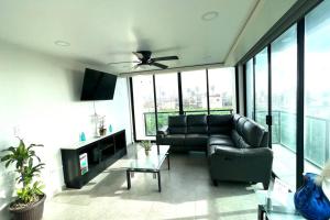 a living room with a couch and a ceiling fan at Luxury 2BR Condo Rosarito (E) in Rosarito