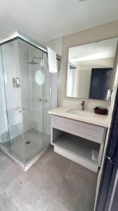 a bathroom with a glass shower and a sink at Luxury 2BR Condo Rosarito (E) in Rosarito