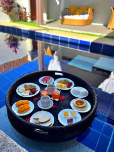 a tray of food on a table with plates of food at Bali Villas Panglao Bohol in Panglao Island
