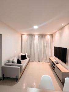 Apartamento inteiro dois quartos próximo ao Centro في ماناوس: غرفة معيشة مع أريكة وتلفزيون بشاشة مسطحة