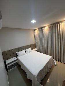 a bedroom with a white bed and a window at Apartamento inteiro dois quartos próximo ao Centro in Manaus