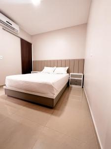 a bedroom with a large bed and a white wall at Apartamento inteiro dois quartos próximo ao Centro in Manaus