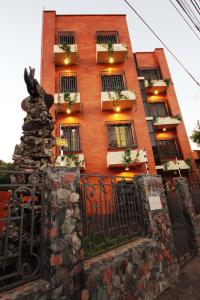 un edificio de ladrillo rojo con cajas de flores y una puerta en OKE Apart Hotel en San Lorenzo