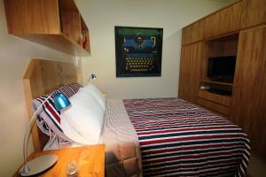 a bedroom with a bed with a wooden headboard at OKE Apart Hotel in San Lorenzo
