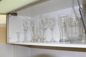 a bunch of wine glasses sitting on a shelf at OKE Apart Hotel in San Lorenzo