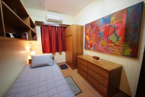 a small room with a bed and a dresser in it at OKE Apart Hotel in San Lorenzo