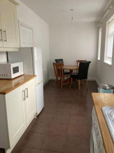 a kitchen with a table and chairs and a microwave at Challoner House - sleeps 5 in Hartlepool
