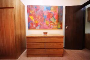 a dresser in a room with a painting on the wall at OKE Apart Hotel in San Lorenzo
