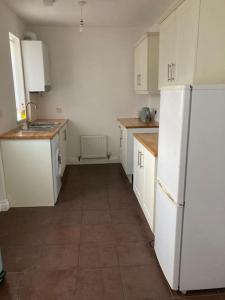 una cucina con armadietti bianchi e frigorifero bianco di Challoner House - sleeps 5 a Hartlepool