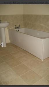 a bathroom with a white tub and a sink at Challoner House - sleeps 5 in Hartlepool