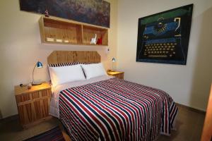 a bedroom with a bed and a picture on the wall at OKE Apart Hotel in San Lorenzo