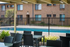 a patio with tables and chairs in front of a pool at Apollo Unit 25 Ground Floor in Narooma