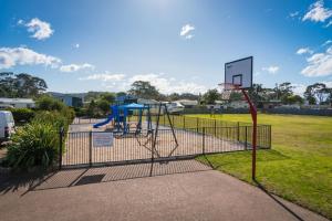 a basketball hoop in a park with a playground at Apollo Unit 25 Ground Floor in Narooma