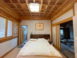 a large bed in a room with a wooden ceiling at Hanok Stay - JukRokJungSa in Gurye