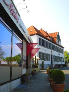 een wit gebouw met rode accenten naast een straat bij Hotel Fürstenberg in Bad Neuenahr-Ahrweiler