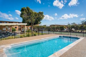 a swimming pool in front of a fence at Apollo Unit 27 - Ground Floor - C Block in Narooma
